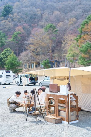 Foto de Una familia instalando una tienda de campaña en un camping y relajándose en un buen día - Imagen libre de derechos