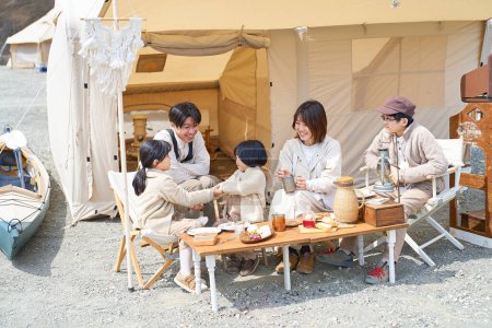 Eine Familie baut ein Zelt auf einem Campingplatz auf und entspannt sich an schönen Tagen