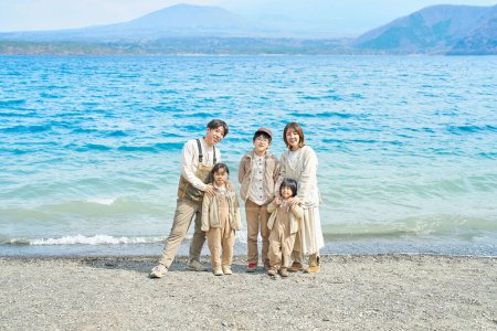 Photo for Asian family standing in front of a lake and enjoying the outdoors - Royalty Free Image