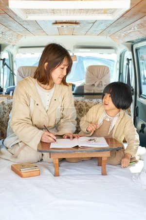 Téléchargez les photos : Mère et fille aiment dessiner dans un camping-car - en image libre de droit