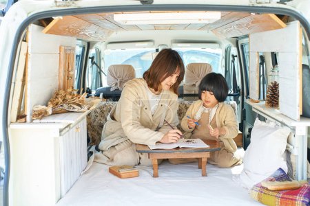 Foto de Madre e hija disfrutando dibujando en una caravana - Imagen libre de derechos