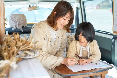 Photo for Mother and daughter enjoying drawing in a camper - Royalty Free Image
