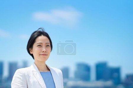 Téléchargez les photos : Femme d'affaires debout à l'extérieur le beau jour - en image libre de droit
