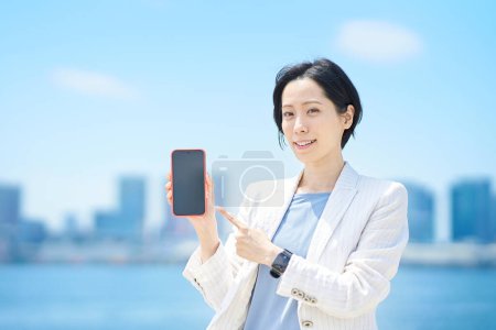 Photo for Business woman with smartphone outdoors in sunny weather - Royalty Free Image