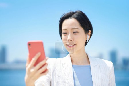 Photo for Business woman with smartphone outdoors in sunny weather - Royalty Free Image