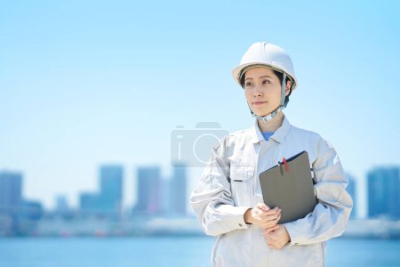Téléchargez les photos : Une femme portant un casque et portant des vêtements de travail le beau jour - en image libre de droit