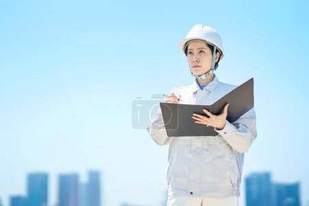 Photo for A woman in work clothes checking the site on fine day - Royalty Free Image
