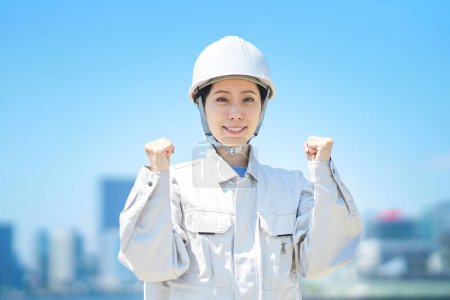 Téléchargez les photos : Une femme vêtue de vêtements de travail pose dehors - en image libre de droit