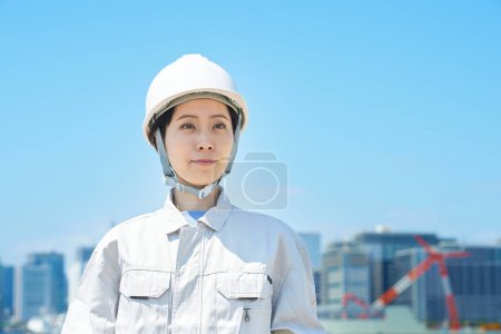 Foto de Una mujer con casco y ropa de trabajo en un buen día - Imagen libre de derechos