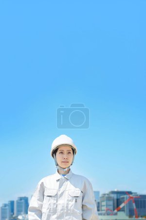 Téléchargez les photos : Une femme portant un casque et portant des vêtements de travail le beau jour - en image libre de droit