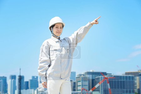 Téléchargez les photos : Une femme en vêtements de travail faisant une pose positive le beau jour - en image libre de droit