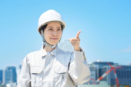 Photo for A woman in work clothes who confirms pointing on fine day - Royalty Free Image