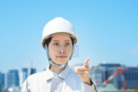 Téléchargez les photos : Une femme en tenue de travail qui confirme pointer du doigt un beau jour - en image libre de droit
