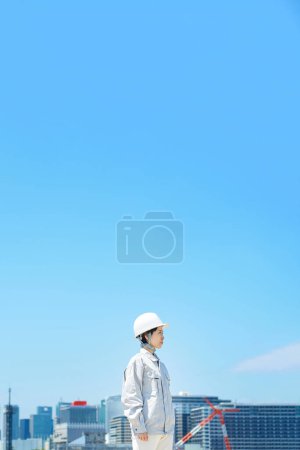 Photo for A woman wearing a helmet and wearing work clothes on fine day - Royalty Free Image