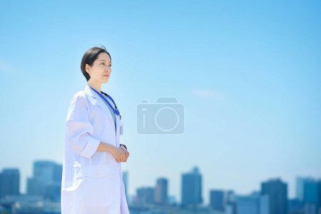Foto de Una mujer con un abrigo blanco y un horizonte soleado - Imagen libre de derechos