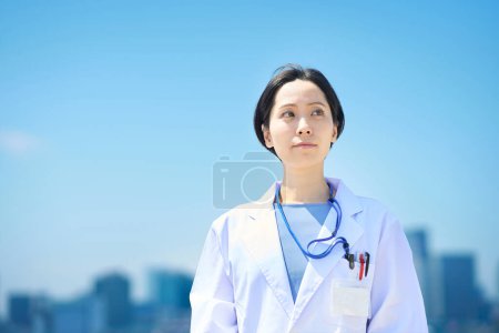 Photo for A woman in a white coat and a sunny skyline - Royalty Free Image