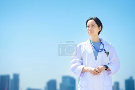 Photo for A woman in a white coat and a sunny skyline - Royalty Free Image