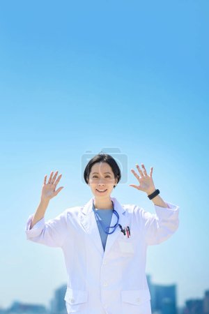 Photo for A woman in a white coat doing a playful pose on fine day - Royalty Free Image