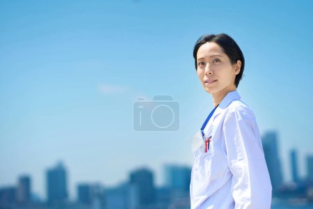 Téléchargez les photos : Une femme en manteau blanc et un horizon ensoleillé - en image libre de droit