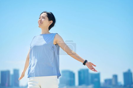 Photo for A woman with a relaxed expression under the blue sky - Royalty Free Image