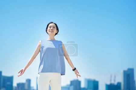 Foto de Una mujer con una expresión relajada bajo el cielo azul - Imagen libre de derechos
