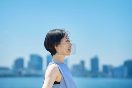 Téléchargez les photos : Une femme avec une expression détendue sous le ciel bleu - en image libre de droit