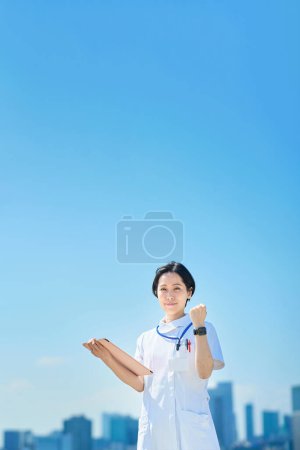 Photo for A woman in a white coat posing for cheering outdoors - Royalty Free Image