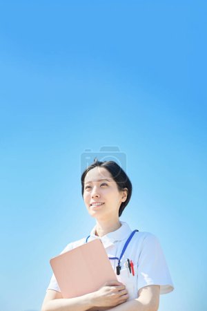 Photo for A woman in a white coat with a file outdoors - Royalty Free Image