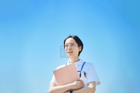 Téléchargez les photos : Une femme en manteau blanc avec une lime à l'extérieur - en image libre de droit