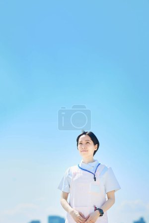 Photo for Woman wearing white coat and apron outdoors - Royalty Free Image