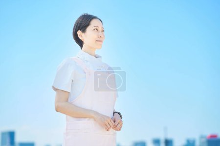 Foto de Mujer con abrigo blanco y delantal al aire libre - Imagen libre de derechos