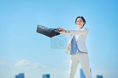 Téléchargez les photos : Femme d'affaires en costume navettant sous le ciel bleu - en image libre de droit