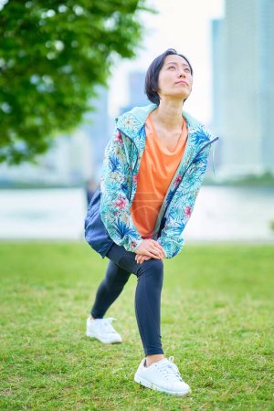 Photo for Asian woman exercising on urban green space - Royalty Free Image