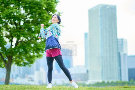 Asian woman exercising on urban green space