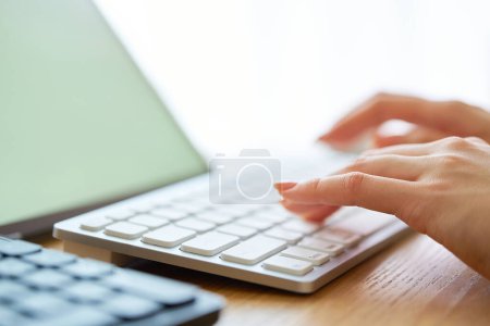 Téléchargez les photos : Main de femme opérant un ordinateur portable dans la pièce - en image libre de droit