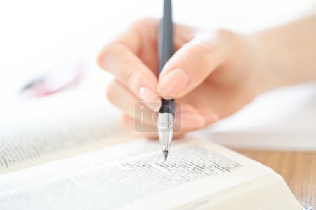 Foto de Primer plano de la mano de una mujer estudiando con texto - Imagen libre de derechos
