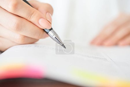 Photo for Close up of a woman's hand studying with text - Royalty Free Image