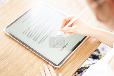 Téléchargez les photos : Main d'une femme qui fait une signature électronique avec un stylet - en image libre de droit