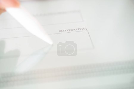 Foto de Mano de una mujer que hace una firma electrónica con un lápiz lápiz óptico - Imagen libre de derechos