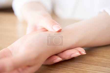 Photo for Hands of a woman measuring her pulse - Royalty Free Image