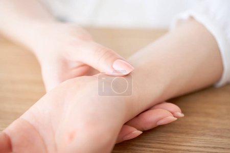 Foto de Manos de una mujer midiendo su pulso - Imagen libre de derechos
