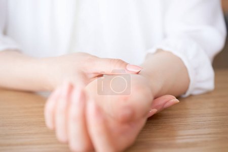 Téléchargez les photos : Mains d'une femme mesurant son pouls - en image libre de droit