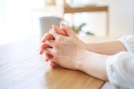 Photo for Hands of a woman who thinks with her hands folded in the room - Royalty Free Image