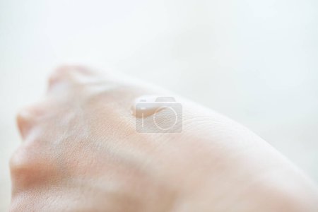 Téléchargez les photos : Main d'une femme qui met une lotion sur sa main - en image libre de droit