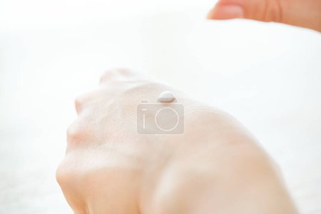 Téléchargez les photos : Main d'une femme qui met de l'émulsion sur sa main - en image libre de droit