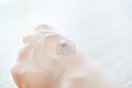 Téléchargez les photos : Main d'une femme qui met de l'émulsion sur sa main - en image libre de droit
