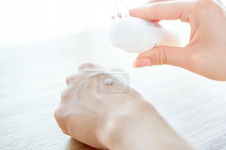 Hand of a woman who puts emulsion on her hand     