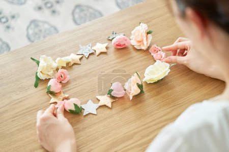 Téléchargez les photos : Les mains d'une femme faisant un cadre avec des accessoires en forme de fleur et en forme d'étoile - en image libre de droit