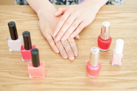 Photo for Nail bottle and woman's hand in the room - Royalty Free Image