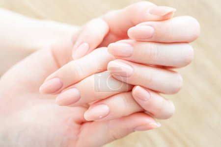 Téléchargez les photos : Une main de femme vérifie l'état de ses ongles - en image libre de droit